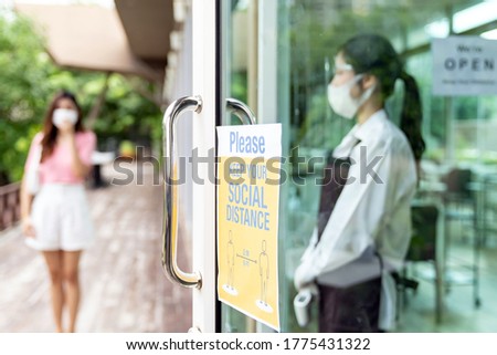 Social distance signage for new normal restaurant with asian waitress ready to welcome customer in background. New normal restaurant lifestyle concept.