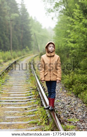 Cute red hair girl walking on railway alone, she is sad. The only one way to travel in coronavirus quarantine time