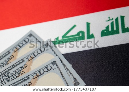 Iraq national flag and the dollar bills. Business and finance concept, soft focus