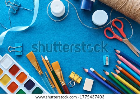 Art materials, products for drawing. Stationery set on blue background