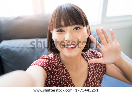 Asian businesswoman holding camera mobile phone taking picture selfie video call team meeting conference chat greeting waving looking at camera smiling joyfully, worker teamwork planning strategy 
