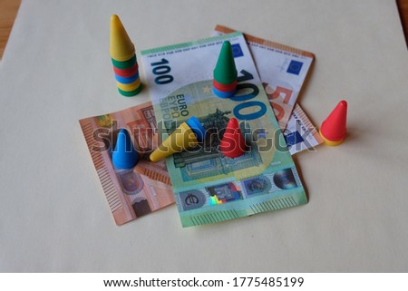 colorful figures stand on some banknotes