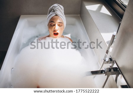 Woman having bathroom full of bubbles