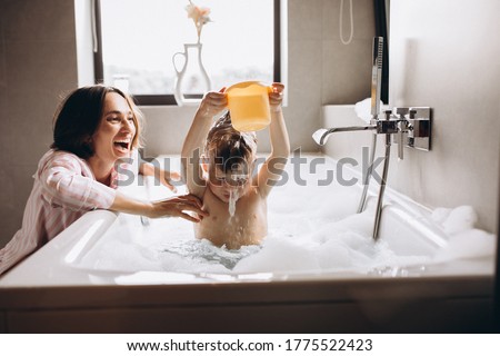 Mother washing little son in bathroom Royalty-Free Stock Photo #1775522423