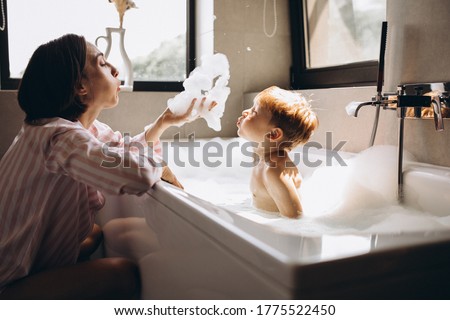 Mother washing little son in bathroom Royalty-Free Stock Photo #1775522450