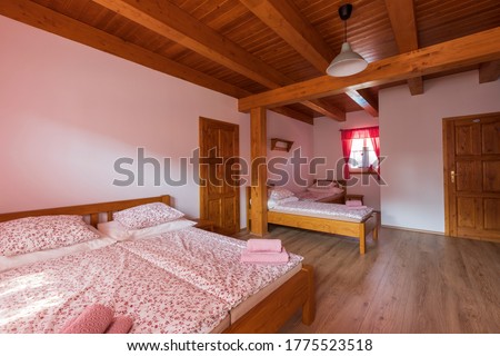 Room with wooden floors and a ceiling with sleeping beds. The beds have a duvet for sleeping.