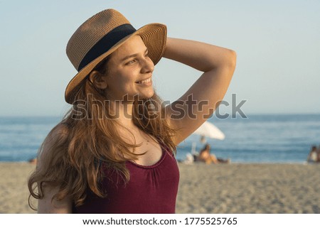 Attractive tourist blonde girl smiling at the beach during summer holidays