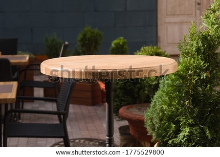 wooden round table in open air cafe Royalty-Free Stock Photo #1775529800