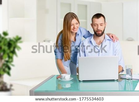 Pleasant family couple sitting and looking at the laptop screen. Royalty-Free Stock Photo #1775534603