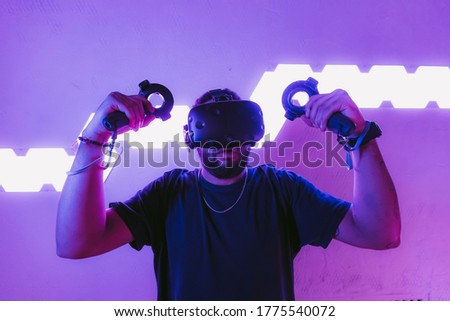 Virtual reality in a neon purple room. Man in VR glasses. High quality photo