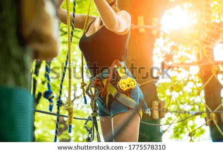 Young woman in adventure rope park. Climbing Equipment.