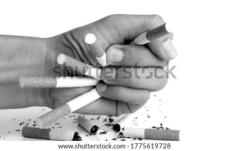 hand of man holds a cigarette in his hand. In order to stop smoke cigarettes is addictive. Health Concepts and Non-Smoking Day.Black and white picture