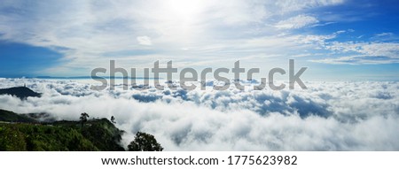 Sunset and Beautiful sky with clouds. Panorama of Fantastic foggy landscape glowing while sunrise in the morning. A beautiful landscape with high mountains foggy cover. Dense fog with beautiful light.