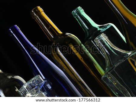 close-up collection of beautiful colored glass bottles on black background studio