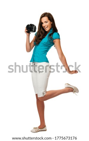 Photography is fun! Young beautiful woman photographer taking images with digital camera and smiling. Isolated on white.