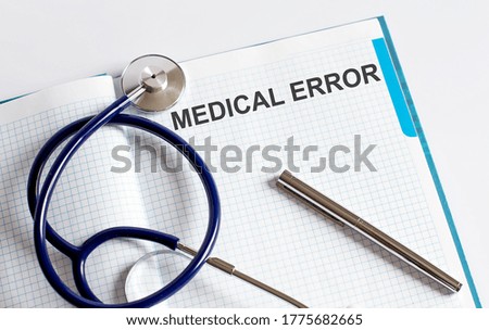 Paper with text MEDICAL ERROR on a table