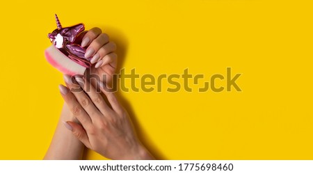 Female hands with a beautiful manicure on a yellow background,top view,flat lay. Manicure concept,banner
