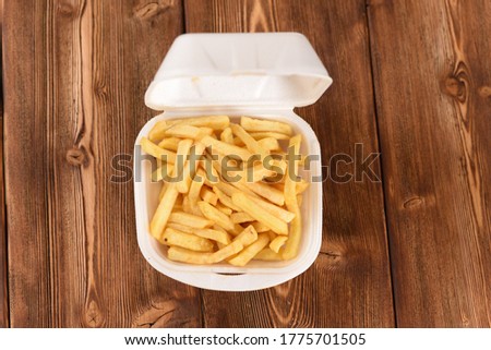 French fries in a plastic box, fast food. Top view.