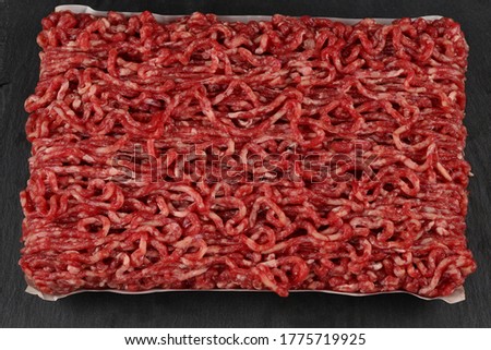 Chopped raw meat  on a black  background.