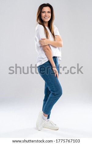 Full portrait of a beautiful young happy woman standing over white background.