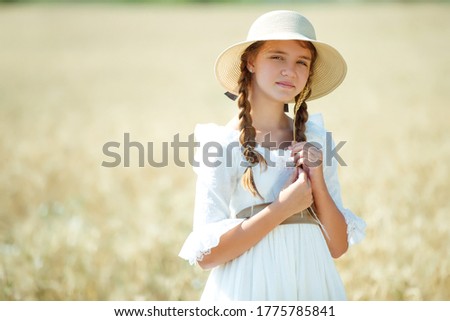 Beautiful girl in wheat in a dress. High quality photo.