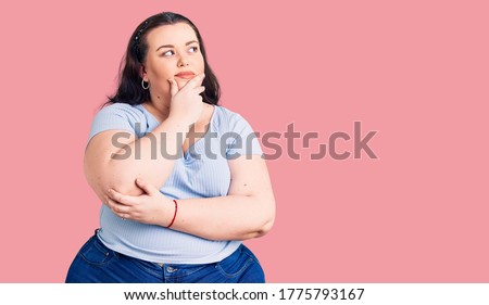 Young plus size woman wearing casual clothes with hand on chin thinking about question, pensive expression. smiling with thoughtful face. doubt concept.  Royalty-Free Stock Photo #1775793167
