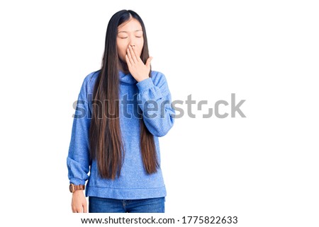 Young beautiful chinese woman wearing casual turtleneck sweater bored yawning tired covering mouth with hand. restless and sleepiness. 