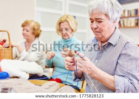 Seniors crochet together in a handicraft course in a retirement home