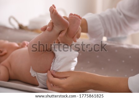 Mother changing her baby's diaper on table, closeup Royalty-Free Stock Photo #1775861825