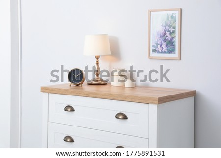 Stylish chest of drawers near light wall. Interior design