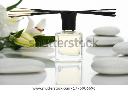selective focus of aroma sticks and perfume near spa stones and lilies isolated on white