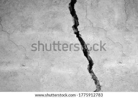 The gray wall of the house with a huge crack. Black and white. Royalty-Free Stock Photo #1775912783