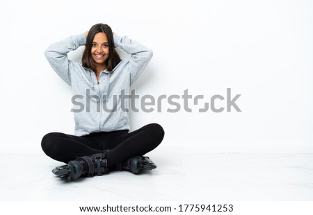 Young asian woman with roller skates on the floor laughing