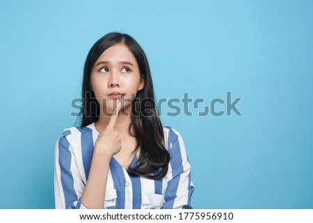young asian woman look up considering think and doubt why Royalty-Free Stock Photo #1775956910