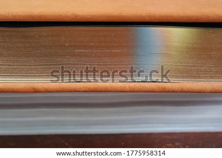 Close up view at a thick old book with golden pages. Side view.