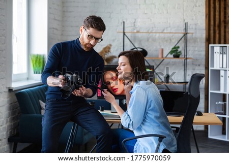Photographer and graphic designer working in office with laptop, monitor, graphic drawing tablet and color palette. Creating team discussing ideas in advertising agency. Retouching images. Teamwork.