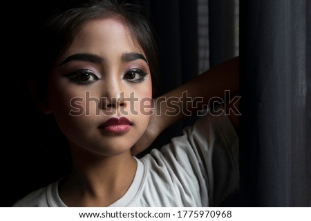 Portrait of an Asian schoolgirl who has been makeup to prepare to perform on stage.