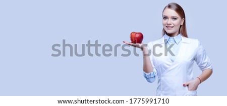 Woman doctor holding red apple, female nurse on isolated background, medical staff