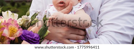 Father's day. A man holds a baby in his arms. Closeup photo of baby and father
