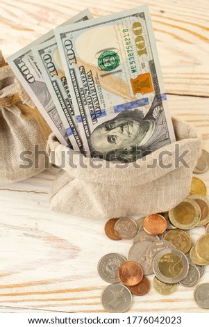 Many small coins and us dollar bill