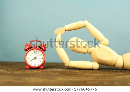 wooden mannequin and red alarm clock, leisure concept