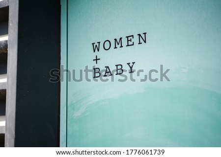 Women and baby writing on the restroom