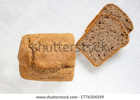 Sliced wheat bread on a linen texture. Fermented whole grain homemade bread.