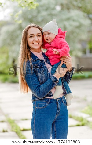 Hilarious young mother and baby daughter outdoors