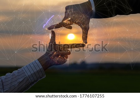 Hands of a businessman show a cropped composition against the backdrop of a sunny sunset.