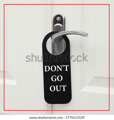 Closed door with sign DON'T GO OUT on handle. Stay at home during coronavirus quarantine