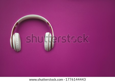 Red wireless headphone on magenta background. top view. space for text