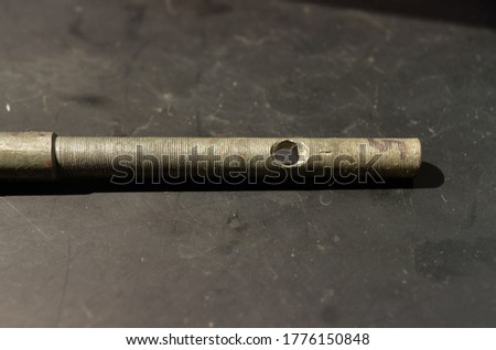 a small special round key with a hole in it lies on a black background