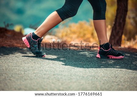 Photo of a Sportive Woman Jogging Outdoors. Body Part. On the Walk. Weight Lost. Active Healthy Lifestyle.
