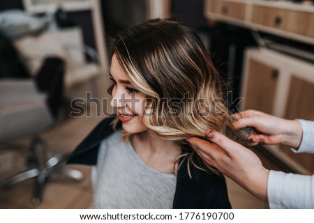Beautiful hairstyle of young woman after dyeing hair and making highlights in hair salon. Royalty-Free Stock Photo #1776190700